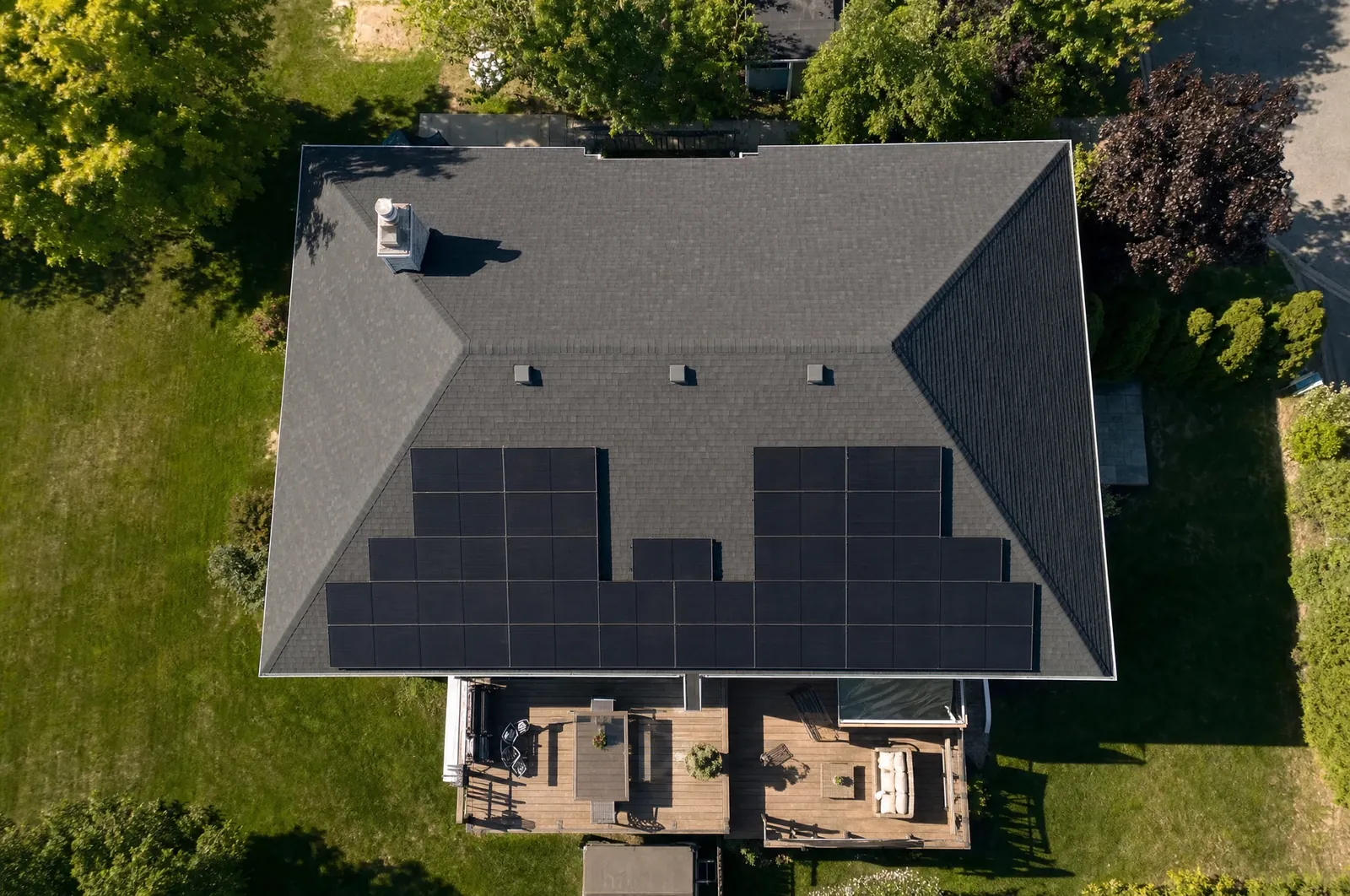 Illustration : vue de drone au-dessus d'une maison, panneaux solaires sur les versants sud du toit