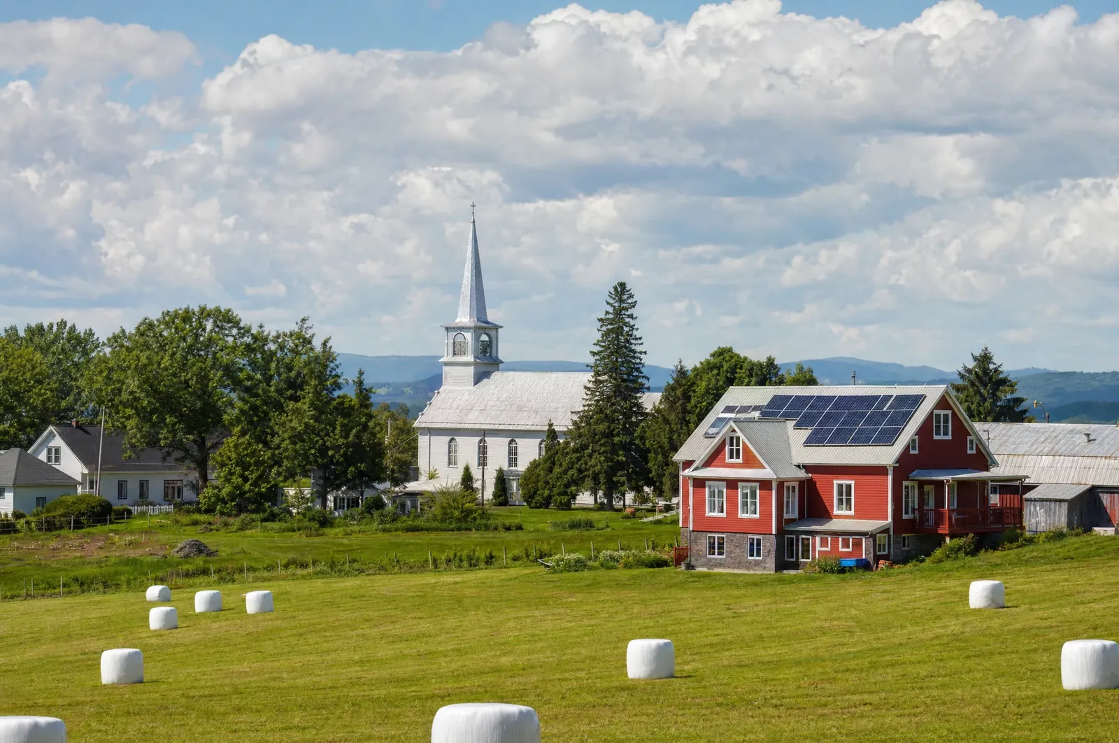 Illustration : village agricole et son église, ferme laitière avec panneaux solaires au toit