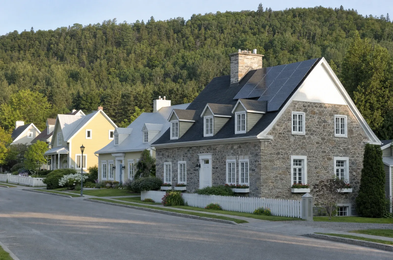 Illustration : rue patrimoniale d'une petite ville au pied des Laurentides, panneaux solaires sur un toit
